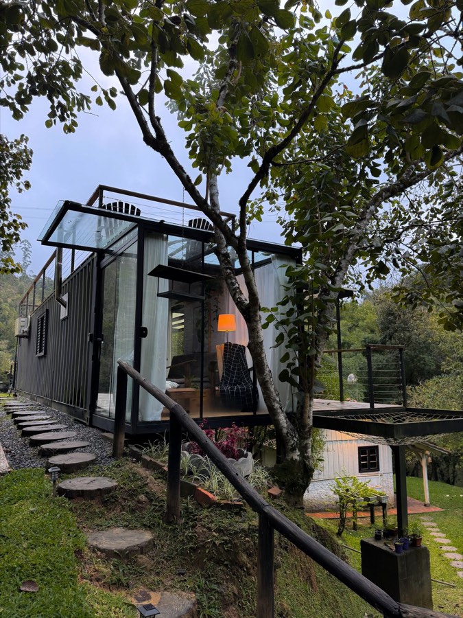 Cabaña modular premium con fachada de vidrio integrada a la naturaleza